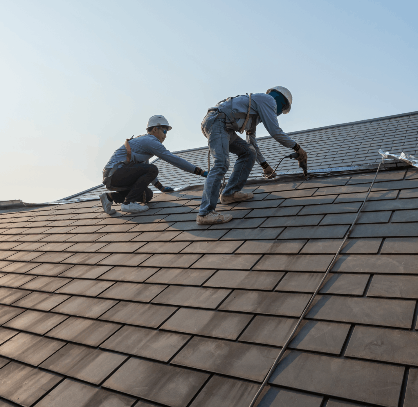 瓦屋根で作業をする職人